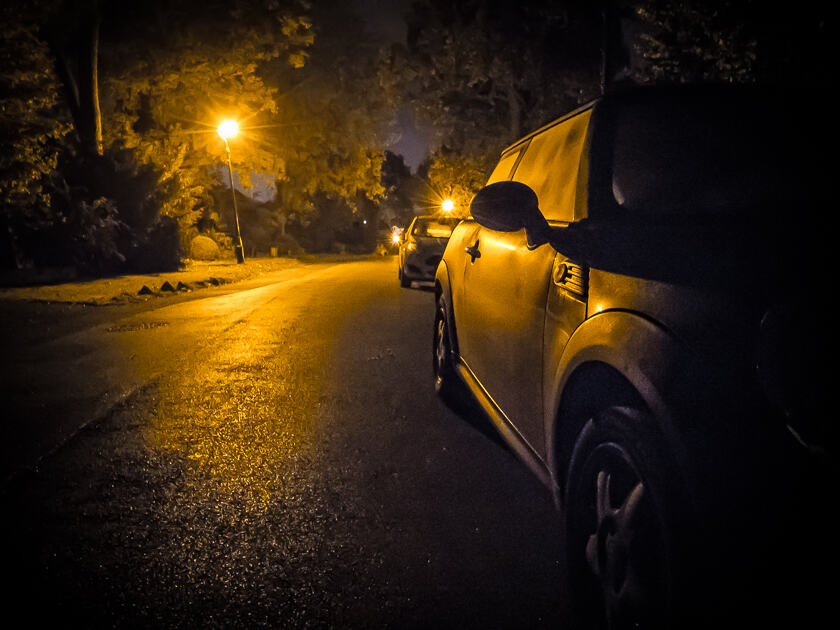 A Mini Cooper lit by a street light at night in Orpington.