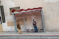 2 men waiting at a bus stop on a very steep road in Chinatown, San Francisco